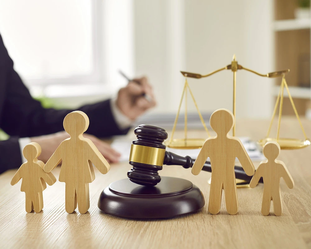 Gavel and wooden family figures with balance scales in the background